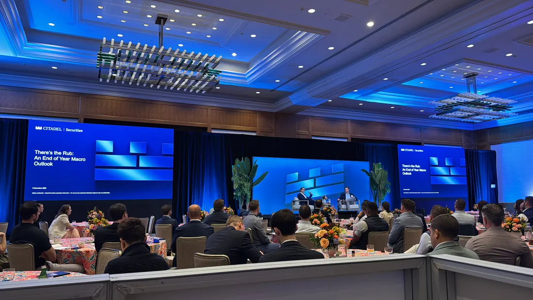 Ballroom conference with blue lighting and three screens
